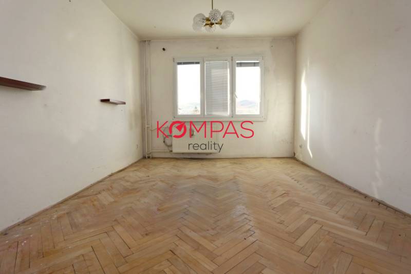 ÚTULNÝ, SVETLÝ 2 IZB.BYT S PRÍJEMNÝM VÝHĽADOM, DETVA - Izba s podlahou s dreveným dekorom v 2-izbovom byte, svetlé steny, stropné svietidlo.