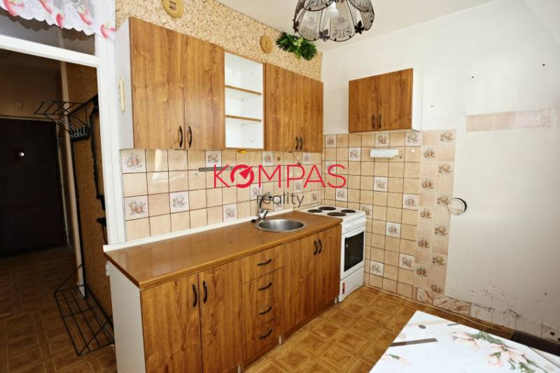 ÚTULNÝ, SVETLÝ 2 IZB.BYT S PRÍJEMNÝM VÝHĽADOM, DETVA - Kuchyňa s drevenými skrinkami v 2-izbovom byte a podlahou s dreveným dekorom.