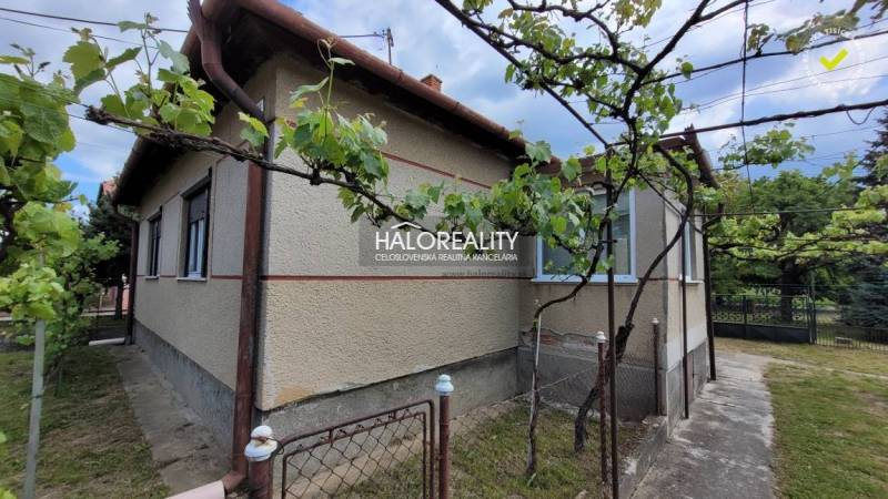 Predaj, rodinný dom Sľažany - EXKLUZÍVNE HALO REALITY - Rodinný dom v Sľažanoch obklopený viničom, s vonkajšou stenou a veľkou záhradou.