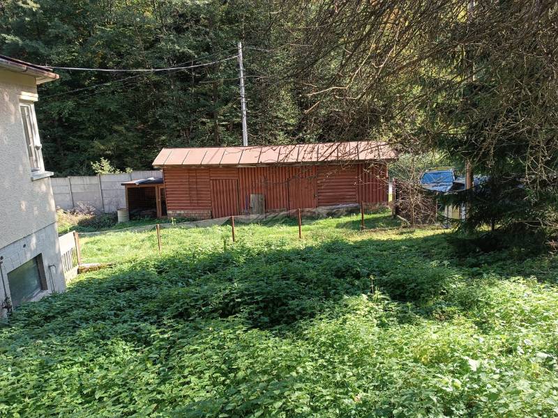 Hospodárska usadlosť  - Záhrada pri rodinnom dome v Horných Hámroch s dreveným prístreškom obklopená zeleňou.