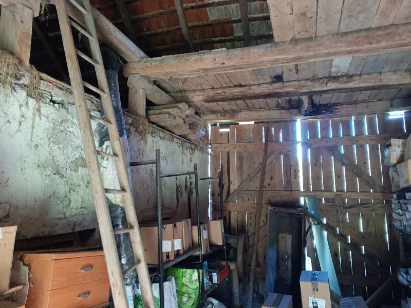 Hospodárska usadlosť  - Sklad v rodinnom dome s dreveným obložením a uloženými krabicami.