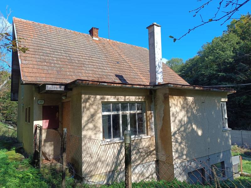 Hospodárska usadlosť  - Rodinný dom v Horných Hámroch s drevenou strechou a za plotom, obklopený zeleňou.