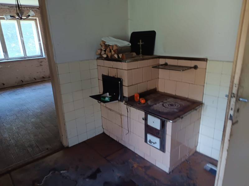 Hospodárska usadlosť  - Staršia kuchyňa v rodinnom dome, s pecou a podlahou s dreveným dekorom.