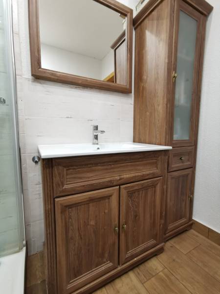 3 izbový byt Zlaté Moravce - Kúpeľňa s umývadlom, zrkadlom a dreveným nábytkom v 3-izbovom byte.