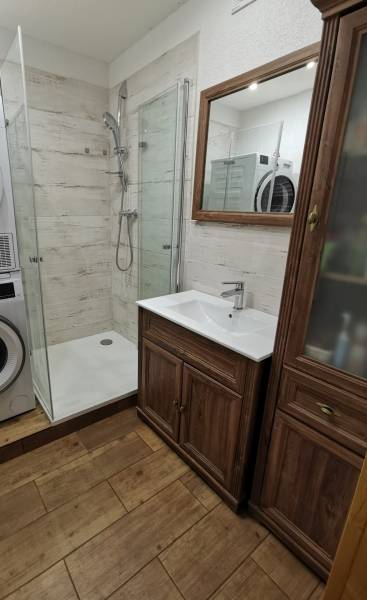 3 izbový byt Zlaté Moravce - Kúpeľňa so sprchovacím kútom, práčkou a podlahou s dreveným dekorom v 3-izbovom byte.