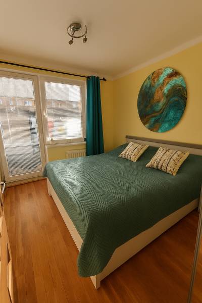 3 izbový byt Zlaté Moravce - Spálňa s podlahou s dreveným dekorom a veľkou posteľou v 3-izbovom byte.