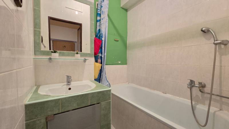 REZERVOVANÉ: NA PREDAJ -  1-izbový byt vo Veľkom Šariši - PREŠOV - Kúpeľňa v 1-izbovom byte s vaňou a zrkadlom na umývadlom.