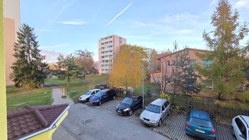 REZERVOVANÉ: NA PREDAJ -  1-izbový byt vo Veľkom Šariši - PREŠOV - Parkovisko a výšková budova na ulici P. O. Hviezdoslava, Veľký Šariš lemované zeleňou.