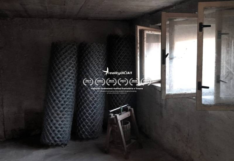 Rodinný dom v obci Dobrá Voda  - Betónová miestnosť v rodinnom dome s rolami pletiva a otvoreným oknom.