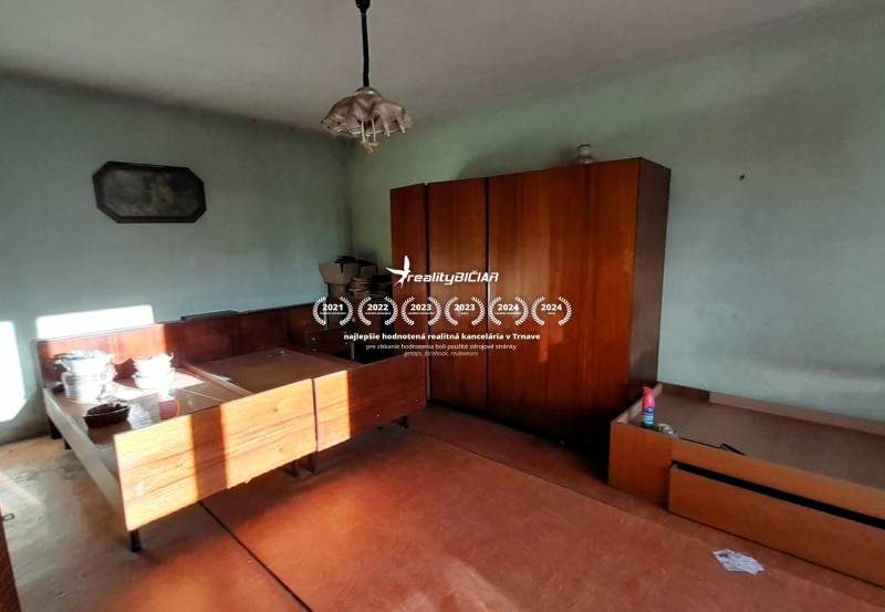 Rodinný dom v obci Dobrá Voda  - Interiér rodinného domu s nábytkom a stolom, podlaha s dreveným dekorom.