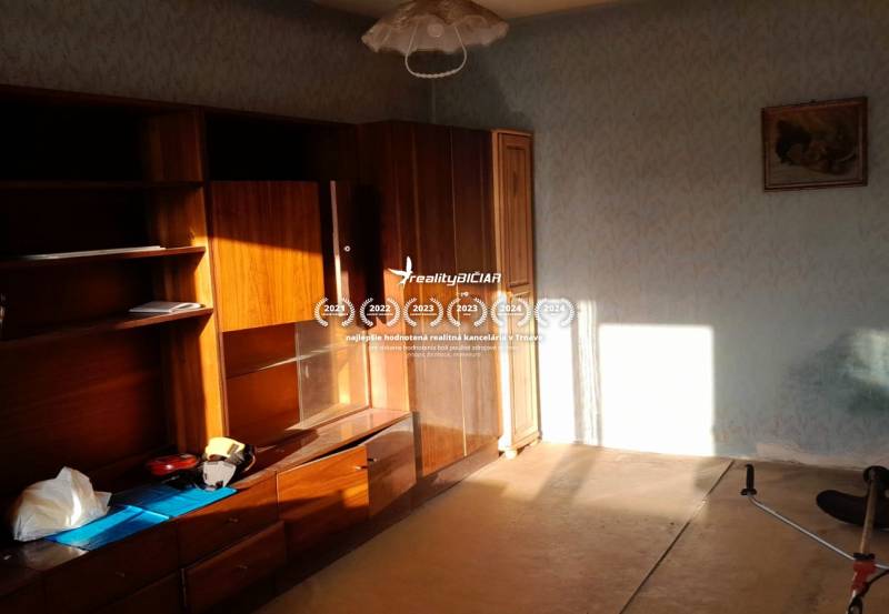 Rodinný dom v obci Dobrá Voda  - Izba s drevenou stenou a svetlom v rodinnom dome, jemné nástenné dekorácie.