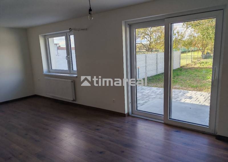 – Podpivničený RD po kompletnej rekonštrukcii - Interiér 3-izbového bytu s veľkými oknami a podlahou s dreveným dekorom.