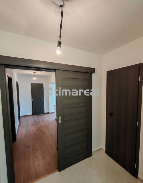 – Podpivničený RD po kompletnej rekonštrukcii - Interiér 3-izbového bytu s podlahou s dreveným dekorom a posuvnými dverami.