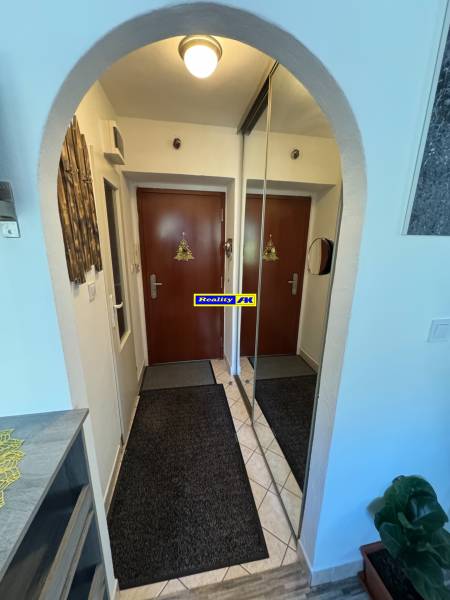 REZERVOVANÉ jednoizbový zrekonštruovaný byt v širšom centre mesta - Vstupná chodba 1-izbového bytu s dlažbou, zrkadlom a koberčekmi.