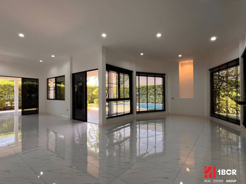 ÚTULNÁ 3 SPÁLŇOVÁ VILA S BAZÉNOM - EAST PATTAYA - Interiér vily s bielymi podlahami a veľkými oknami s výhľadom na záhradu.