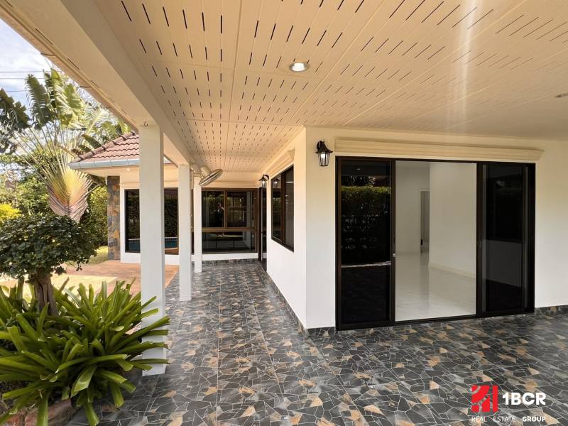 ÚTULNÁ 3 SPÁLŇOVÁ VILA S BAZÉNOM - EAST PATTAYA - Pattayská vila s terasou, sklenenými dverami, rastlinami a mozaikovou dlažbou v záhrade.