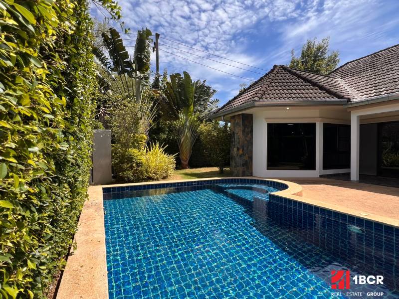 ÚTULNÁ 3 SPÁLŇOVÁ VILA S BAZÉNOM - EAST PATTAYA - Vila v Pattayi s bazénom obklopená zeleňou a modrou oblohou.