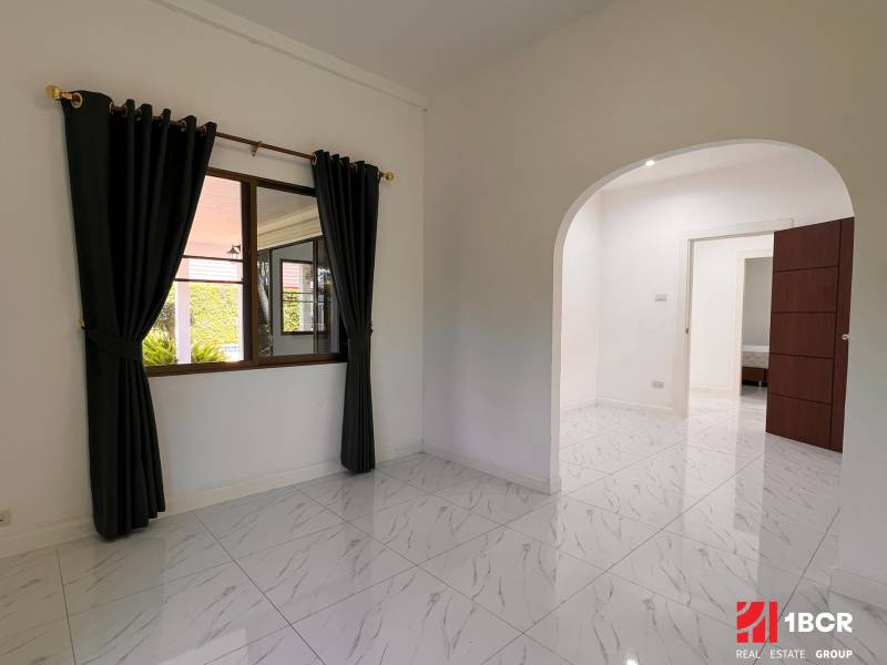 ÚTULNÁ 3 SPÁLŇOVÁ VILA S BAZÉNOM - EAST PATTAYA - Interiér vily s kachľovou podlahou, oblúkovými dverami a závesmi na okne.