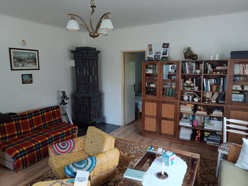 Hospodárska usadlosť s 3,6 hektárovým pozemkom na samote Nová Baňa - Obývacia izba s kachľami, drevenými skriňami a typickým rodinným domovým nábytkom.