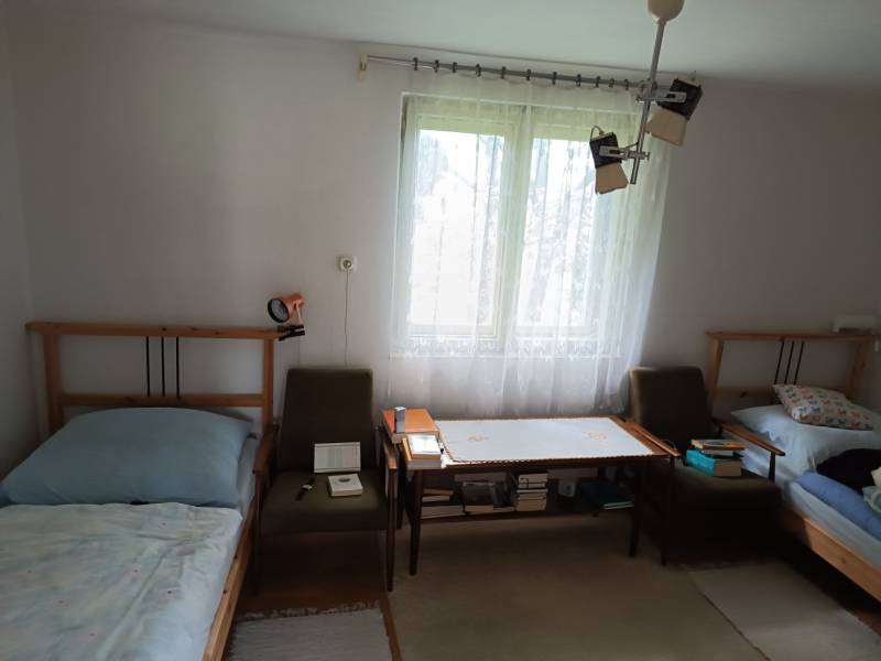 Hospodárska usadlosť s 3,6 hektárovým pozemkom na samote Nová Baňa - Izba so svetlým interiérom, dve postele, kreslá, okno, stolík, rodinný dom.