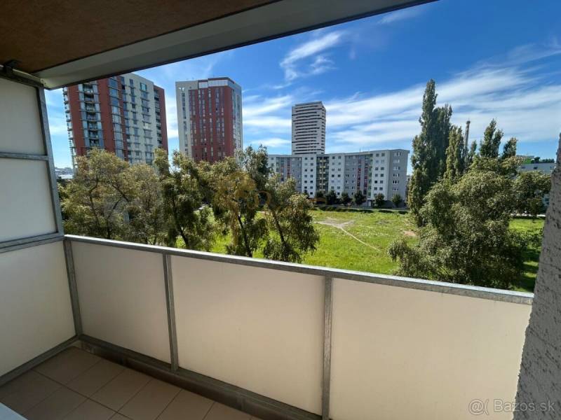 Veľký 2-izb. byt na ul. Vranovská, Petržalka, lodžia, 4.p./7 - Balkón garsónky na Vranovskej ulici v Bratislave - Petržalke s výhľadom na zeleň a paneláky.