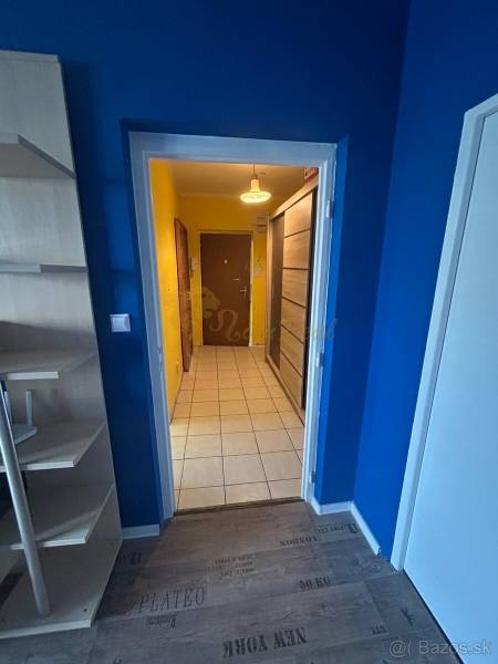 Veľký 2-izb. byt na ul. Vranovská, Petržalka, lodžia, 4.p./7 - Garsónka s farebnými stenami, bielym dverami a podlahou s dreveným dekorom.