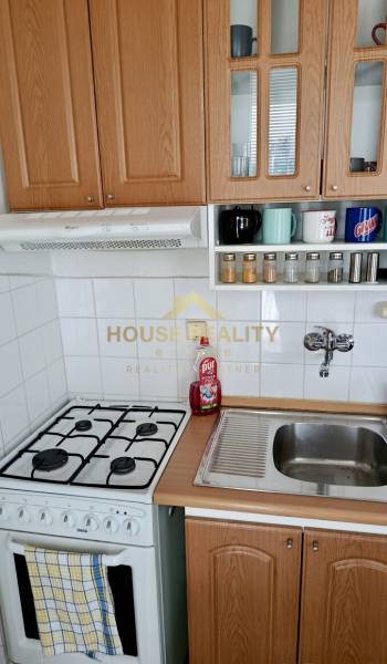 Pekný 1 izbový byt, Tilgnerova ulica, Bratislava IV. Karlova Ves - Kuchyňa v 1-izbovom byte s plynovým sporákom a drevenými skrinkami.