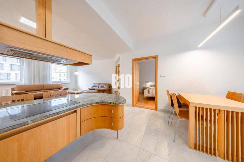 POD HRADOM - ZÁMOCKÁ - 3 IZBOVÝ BYT NA BÝVANIE AJ INVESTÍCIU - Interiér 3-izbového bytu s otvorenou obývačkou, jedálenským stolom a priestorom na varenie.