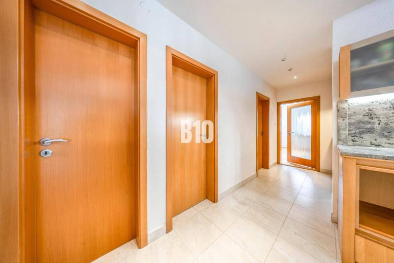 POD HRADOM - ZÁMOCKÁ - 3 IZBOVÝ BYT NA BÝVANIE AJ INVESTÍCIU - Chodba v 3-izbovom byte s viacerými dverami a svetlou dlažbou.