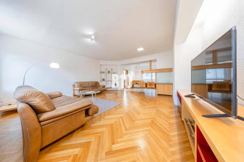 POD HRADOM - ZÁMOCKÁ - 3 IZBOVÝ BYT NA BÝVANIE AJ INVESTÍCIU - Obývacia izba v 3-izbovom byte s koženými sedačkami a podlahou s dreveným dekorom.