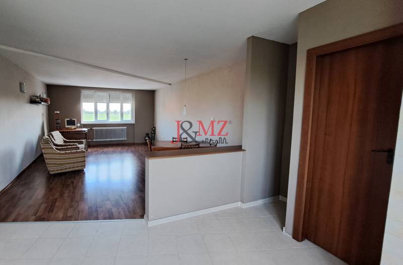 Rodinný dom, garáž a záhrada 1.400 m2, Hronské Kosihy (SM–847) - Interiér rodinného domu s obývačkou, sedačkou a počítačom pri okne.