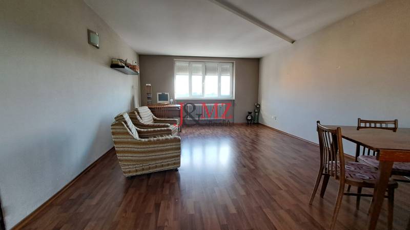 Rodinný dom, garáž a záhrada 1.400 m2, Hronské Kosihy (SM–847) - Obývacia izba v rodinnom dome s drevenou podlahou, gaučom a stolom.