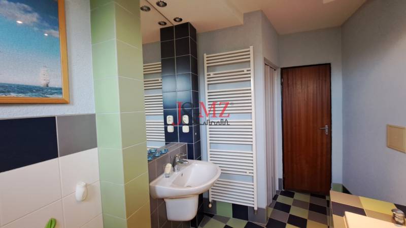 Rodinný dom, garáž a záhrada 1.400 m2, Hronské Kosihy (SM–847) - Kúpeľňa v rodinnom dome s umývadlom, sprchou a obrazom plachetnice.