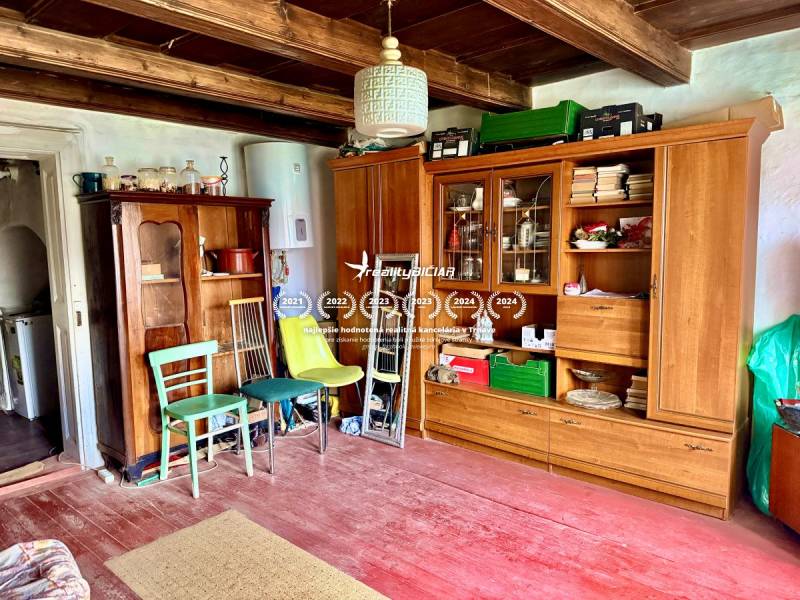 Dom v Budmericiach s možnosťou rekreácie aj trvalého bývania - Obývacia izba v rodinnom dome s dreveným stropom a starožitným nábytkom.