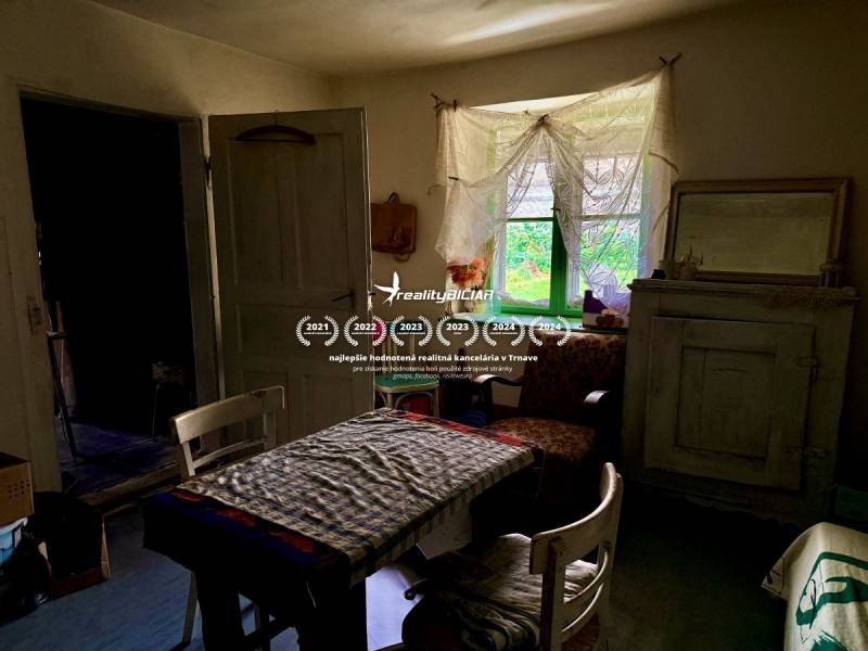 Dom v Budmericiach s možnosťou rekreácie aj trvalého bývania - Interiér rodinného domu so starožitným nábytkom, kvetinovým vzorom a vidieckou atmosférou.