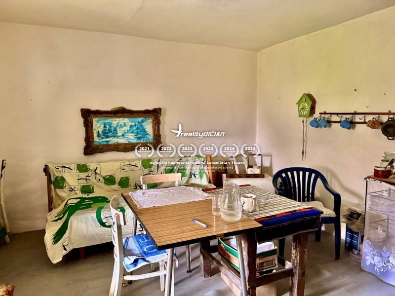 Dom v Budmericiach s možnosťou rekreácie aj trvalého bývania - Jedáleň v rodinnom dome s farebnými dekoráciami a obrazom na stene.