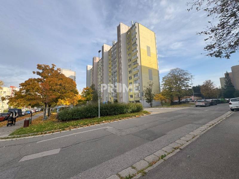 Príjemný 1i byt, zariadený, pivnica, Drobného ul., Dúbravka - Výšková budova na ulici Drobného, Bratislava - Dúbravka, obklopená zeleňou a autami.