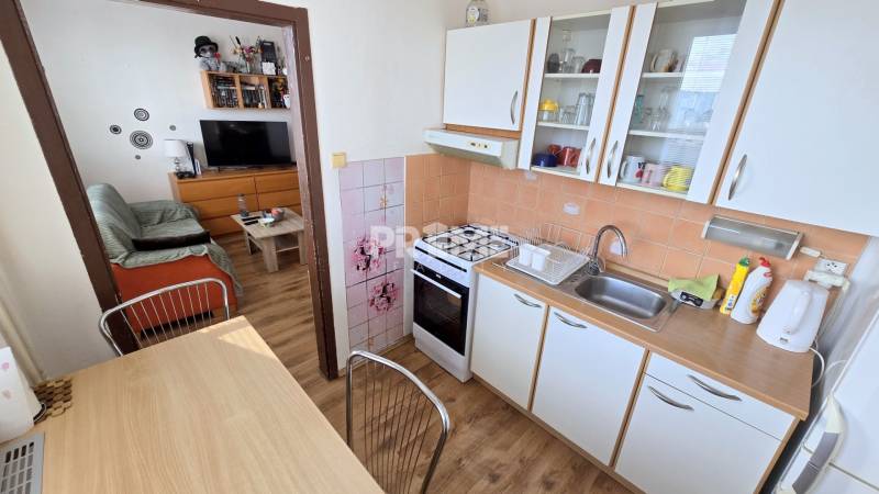 Príjemný 1i byt, zariadený, pivnica, Drobného ul., Dúbravka - Kuchyňa a obývací priestor v 1-izbovom byte s podlahou s dreveným dekorom.