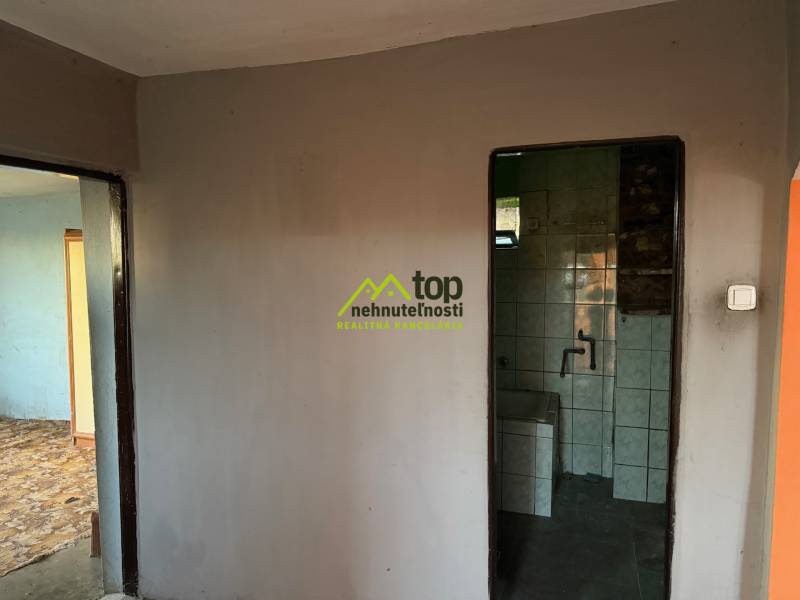 RD TVRDOMESTICE, pozemkom s prístupom z oboch strán - Pohľad do kúpeľne v rodinnom dome s dlaždicami a bielymi stenami.