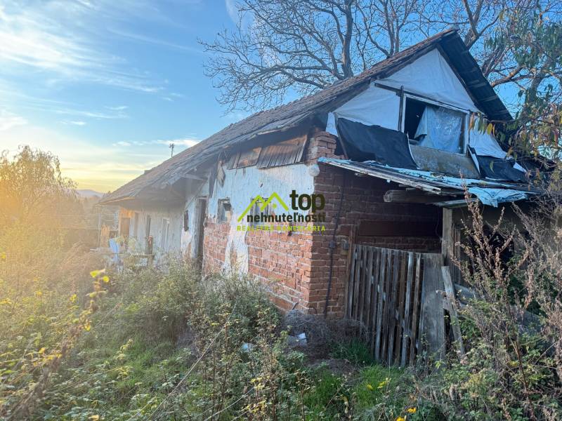 RD TVRDOMESTICE, pozemkom s prístupom z oboch strán - Starý rodinný dom v Tvrdomesticiach s poškodenou strechou a zanedbanou záhradou.