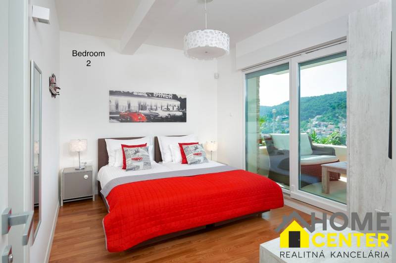 KRÁSNA MODERNÁ VILA  /400 m²/ s výhľadom na more, ostrov BRAČ - Spálňa vo vile s podlahou s dreveným dekorom, posteľou a balkónom s výhľadom.