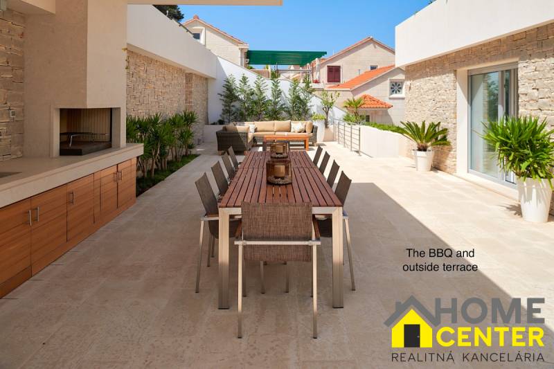 KRÁSNA MODERNÁ VILA  /400 m²/ s výhľadom na more, ostrov BRAČ - Vila v meste Bol s vonkajšou terasou, stolom a grilom obklopená rastlinami.