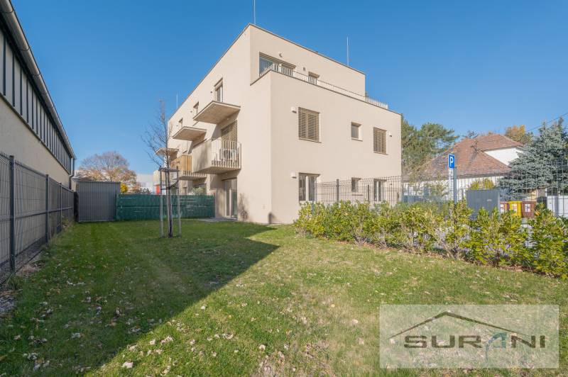 2-izbový byt s predzáhradkou 135 m² a parkovaním v tichej časti BA - Budova s dvomi poschodiami, zelená tráva a modrá obloha na Železničnej ulici v Bratislave.