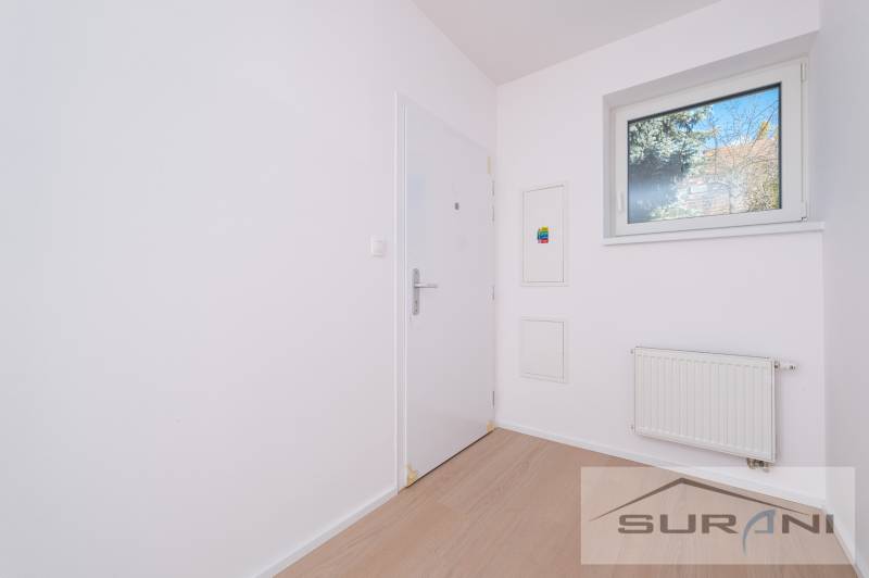 2-izbový byt s predzáhradkou 135 m² a parkovaním v tichej časti BA - Vstupná predsieň v 2-izbovom byte s podlahou s dreveným dekorom a oknom.