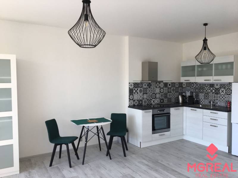 PRENÁJOM 1i byt s Loggiou, Tomášikova ul., Ružinov - Kuchyňa v 1-izbovom byte s jedálenským stolom a podlahou s dreveným dekorom.