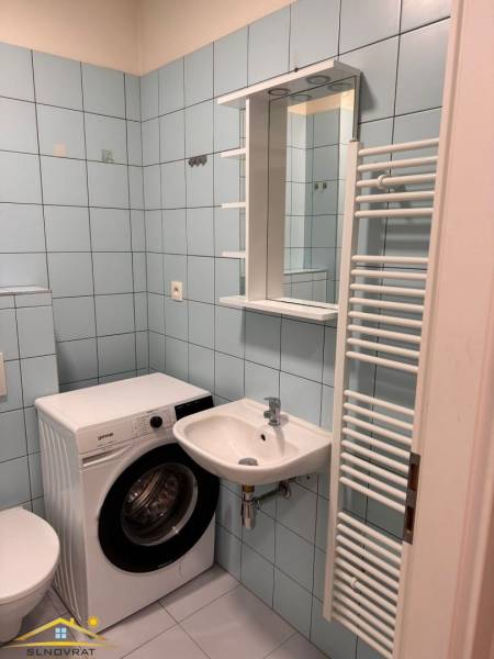 Predaj : 1 izbový byt v meste Čadca časť Žarec  (336-B) - Kúpeľňa v 1-izbovom byte s práčkou a umývadlom, svetlomodré obklady.