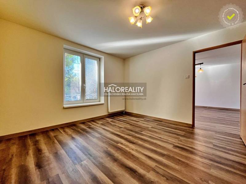 REZERVOVANÉ - Predaj, trojizbový byt Želiezovce, zre... - Izba v 3-izbovom byte s podlahou s dreveným dekorom a veľkým oknom.