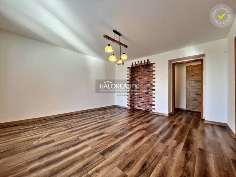 REZERVOVANÉ - Predaj, trojizbový byt Želiezovce, zre... - Obývacia izba v 3-izbovom byte s podlahou s dreveným dekorom a tehlovou stenou.