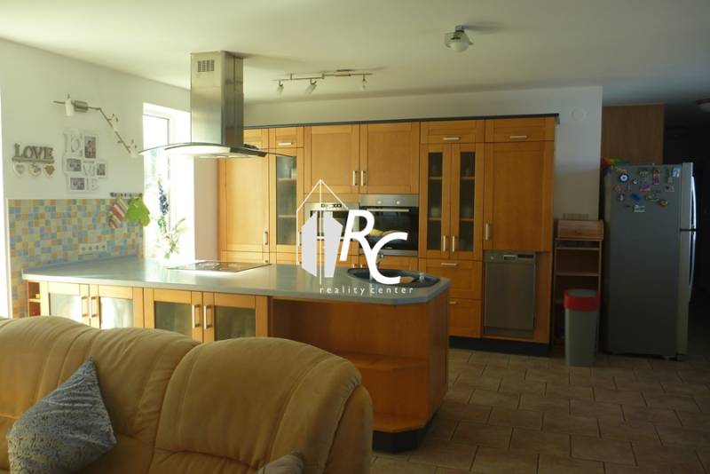 EXKLUZÍVNE, VEĽKÝ RODINNÝ DOM NECPALY - Kuchyňa rodinného domu s drevenou kuchynskou linkou a nerezovými spotrebičmi.