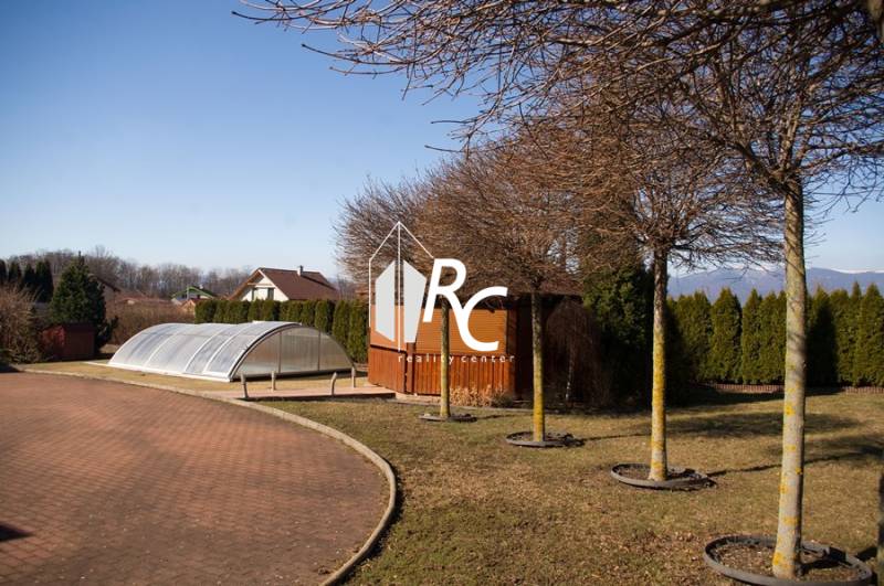 EXKLUZÍVNE, VEĽKÝ RODINNÝ DOM NECPALY - Dvor rodinného domu v Necpaloch s bazénom a altánkom, obklopený stromami.